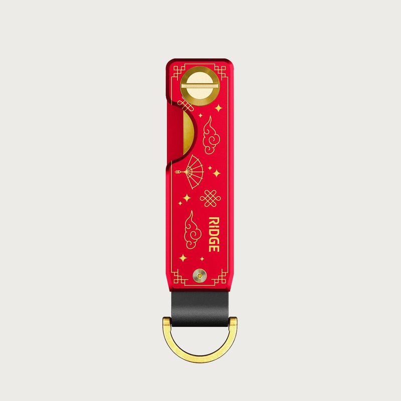 Ridge KeyCase in red with gold Fire Horse engravings, front view with black leather loop and gold D-ring.